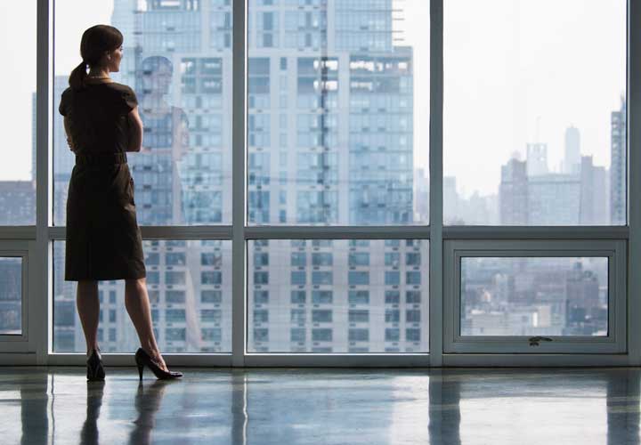 Woman looking out windows in a commercial building